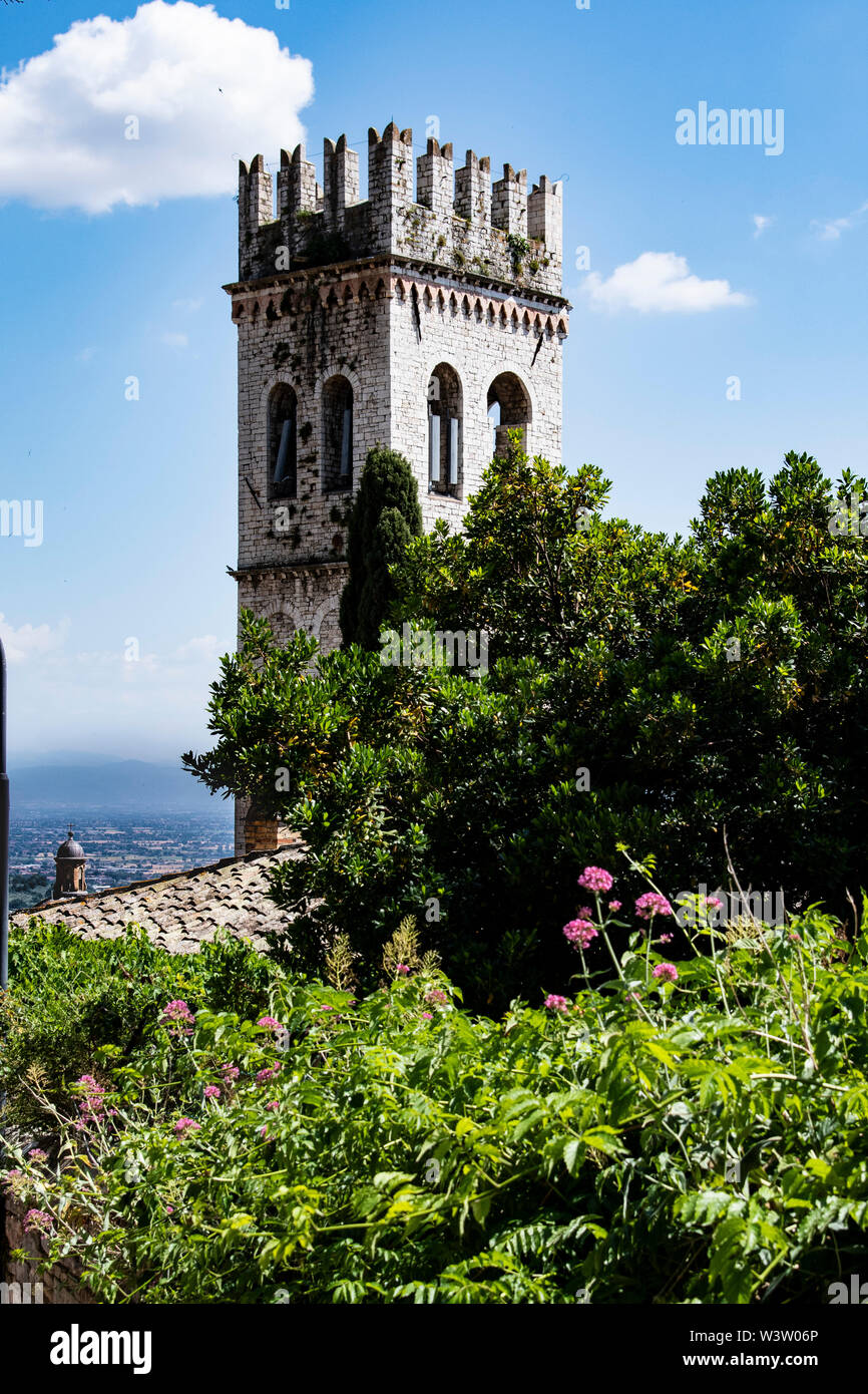 Medieval town hall tower and facade of Santa Maria Sopra Minerva, ancient church of Assisi, Umbria build over a roman age temple Stock Photo