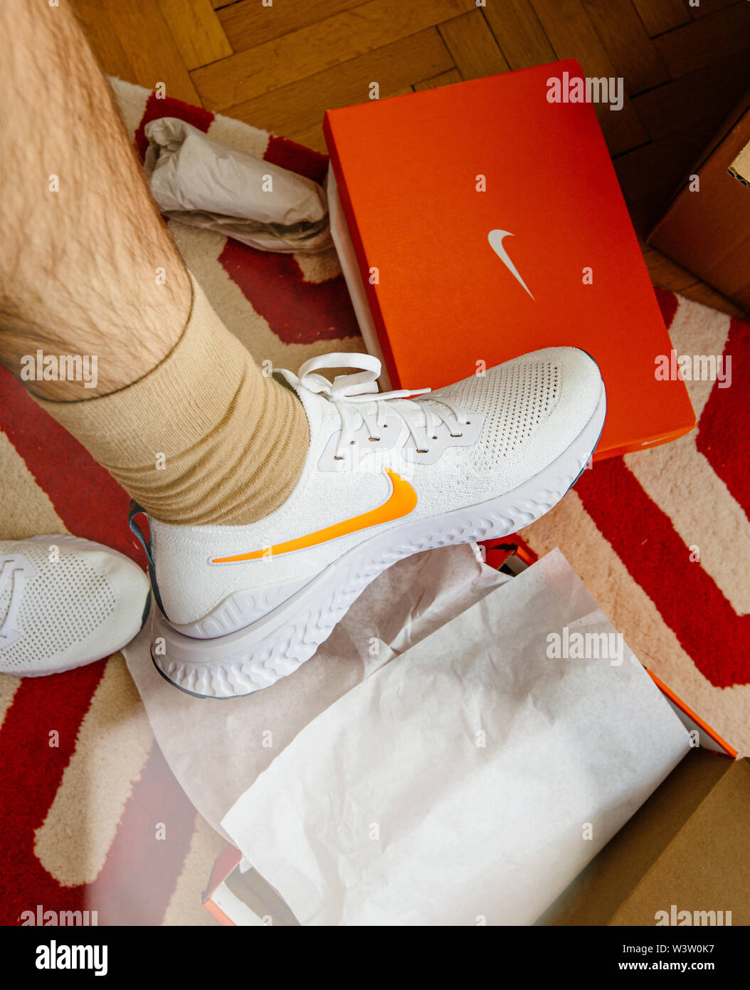 Paris France - Jul 13 2019: Man unboxing measuring new Nike Epic React  Flyknit 2 running shoes equipment with cardboard box manufactured by Nike  sportswear white logotype on side of the shoe Stock Photo - Alamy