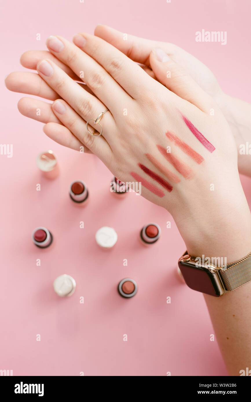 Swatch lipstick on the thin hand of a girl. Swatches of different lipsticks on the background of