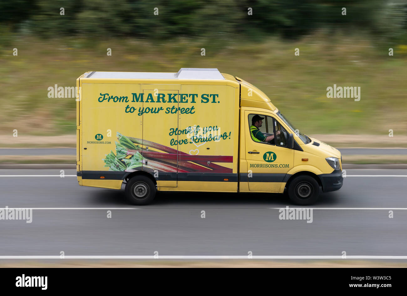 A Morrison's delivery van travels along the A556 road in Alderley Edge, Cheshire, UK. Stock Photo