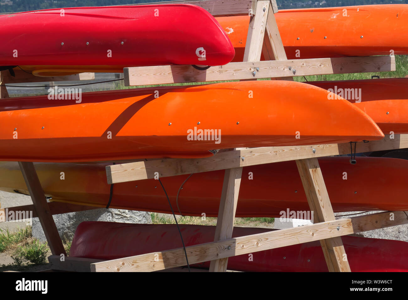 Colourful red and orange kayaks waiting to be rented out. Crescent Beach, B. C., Canada Stock Photo