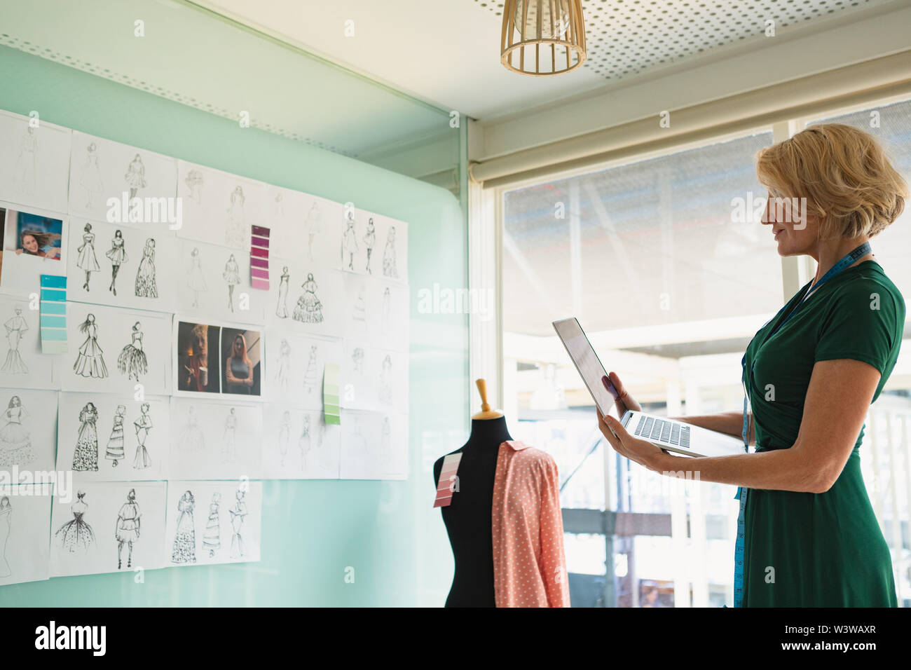 Female fashion designer using laptop in design studio Stock Photo - Alamy