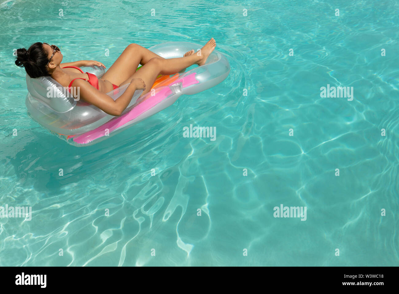 Woman in bikini relaxing on a inflatable tube in swimming pool at the  backyard of home Stock Photo - Alamy