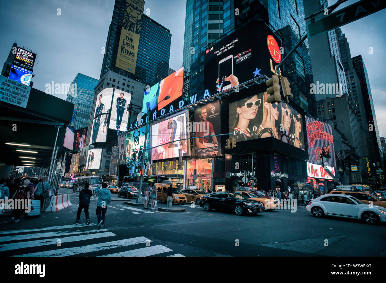 New York City, USA - May 20, 2014: Times Square during a calm evening. People are walking on the sidewalks, taxis are on the street and advertising bi Stock Photo