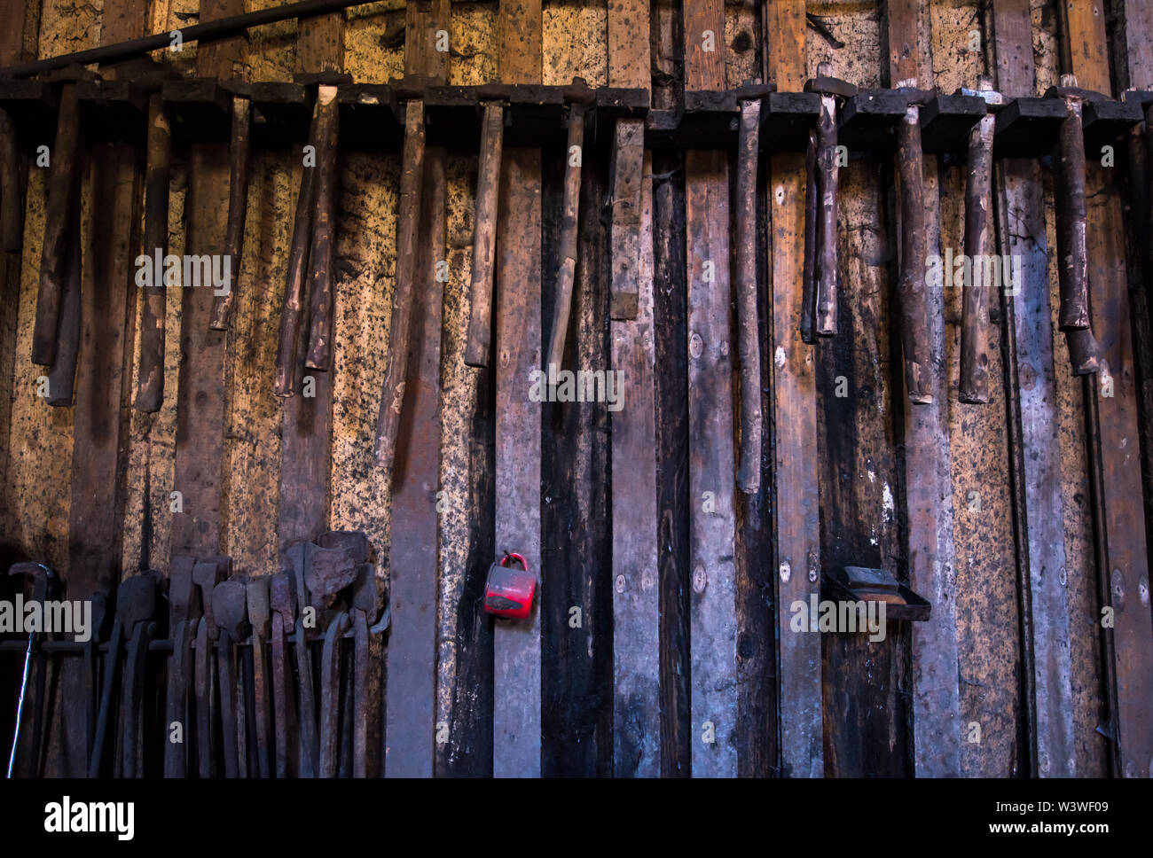 blacksmith tools hanging on a wooden wall Stock Photo