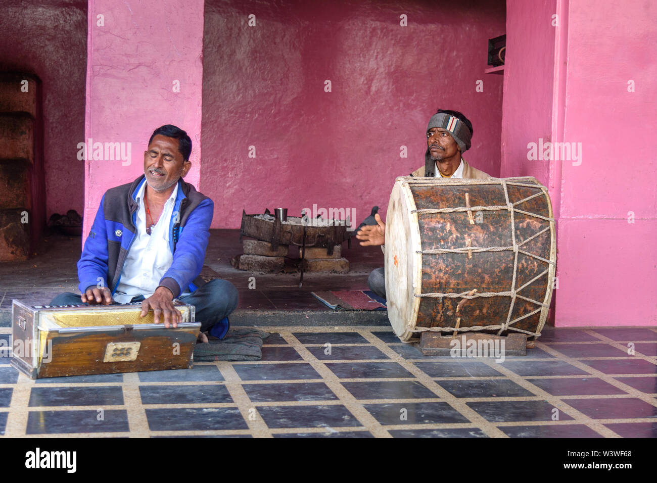 Deshnok, India - February 11, 2019: Indian men playing the drum and Harmonium in Karni Mata Temple or Rats Temple in Deshnok. Rajasthan Stock Photo