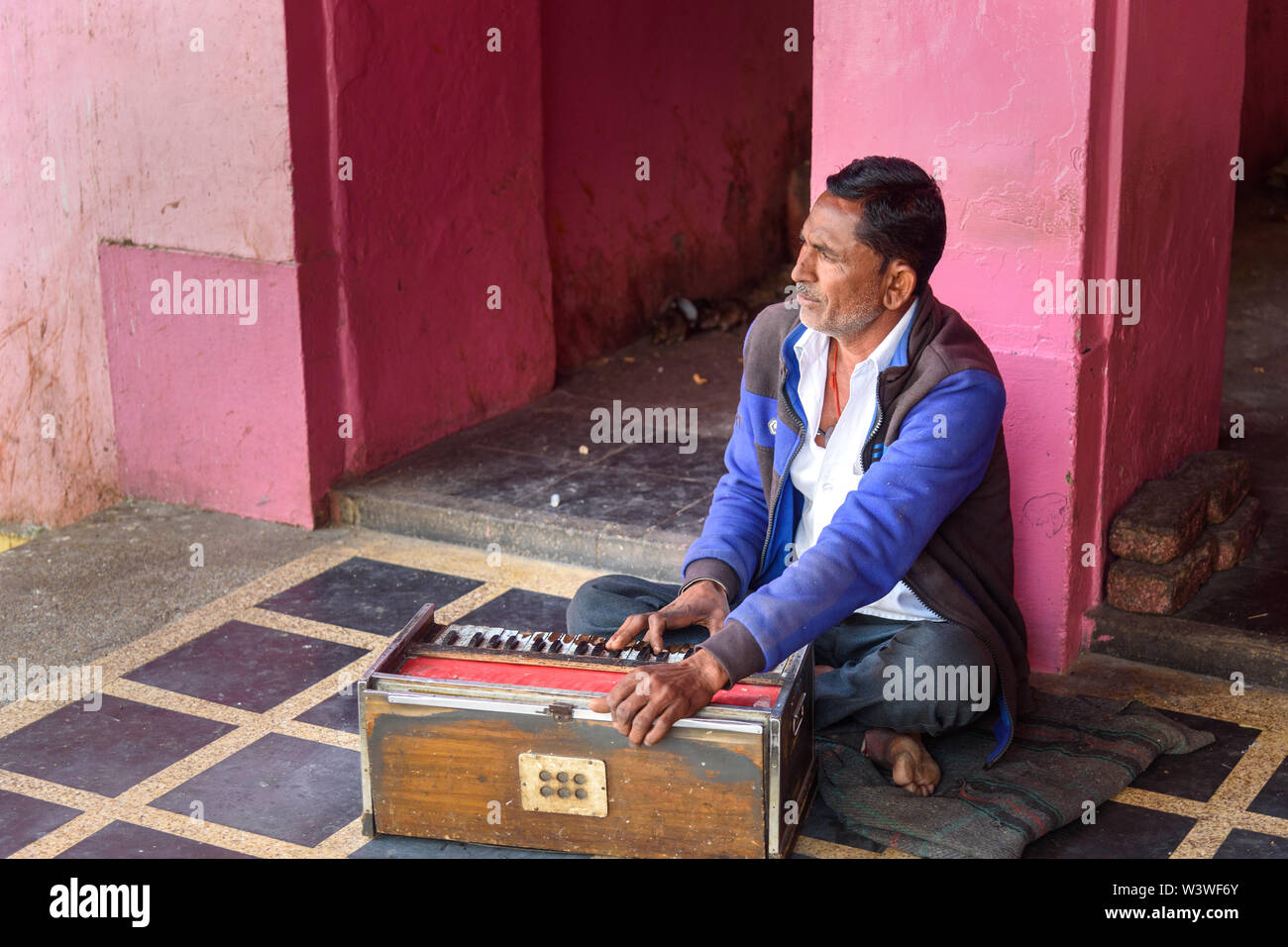 Deshnok, India - February 11, 2019: Indian man playing the Harmonium in Karni Mata Temple or Rats Temple in Deshnok. Rajasthan Stock Photo