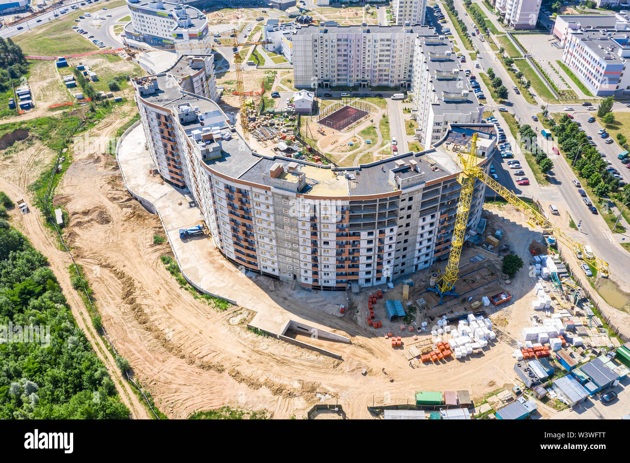aerial view of city construction site with high yellow industrial tower ...