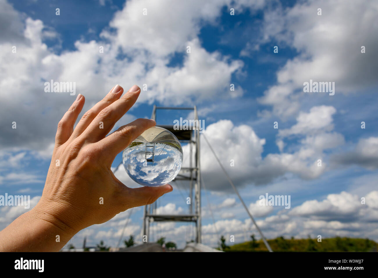 Hand holding lensball with sky and bridge Stock Photo