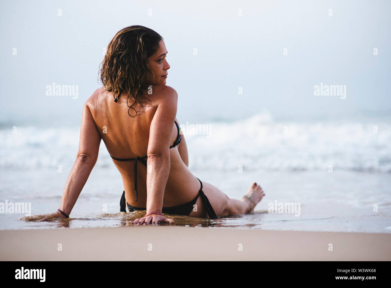 Woman with bikini sunbathing on the beach. Stock Photo