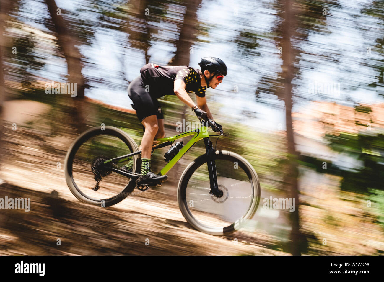 Speed blur of male mountain bike cyclist going downhill Stock Photo