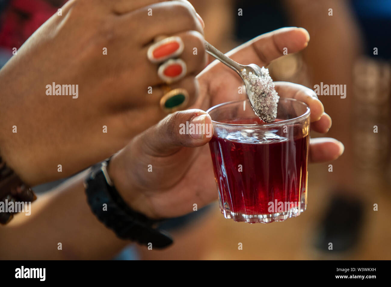 Close up of sugar being added to a glass of hibiscus tea in Egypt Stock Photo