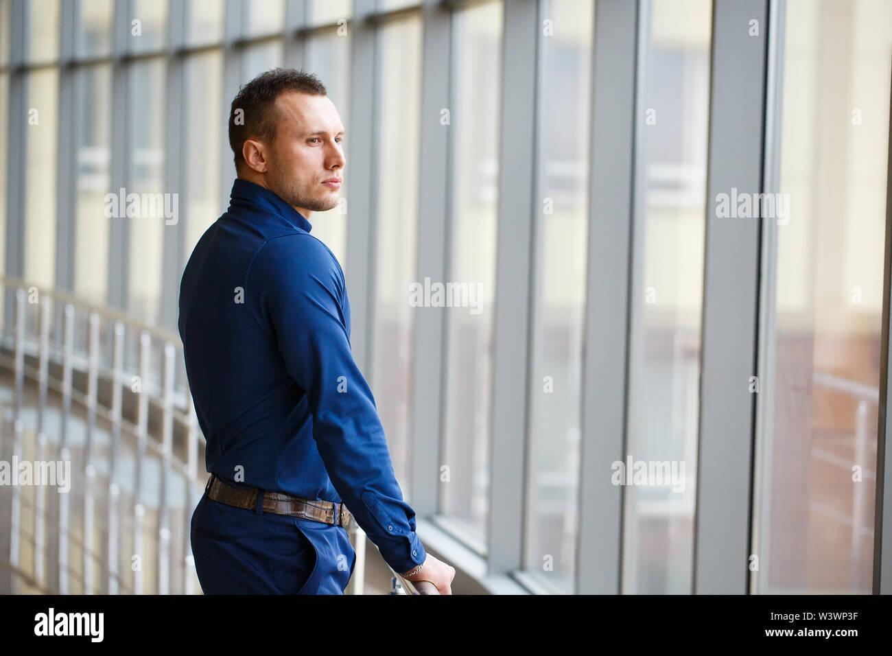 Businessman standing near the window and looking into it. Stock Photo