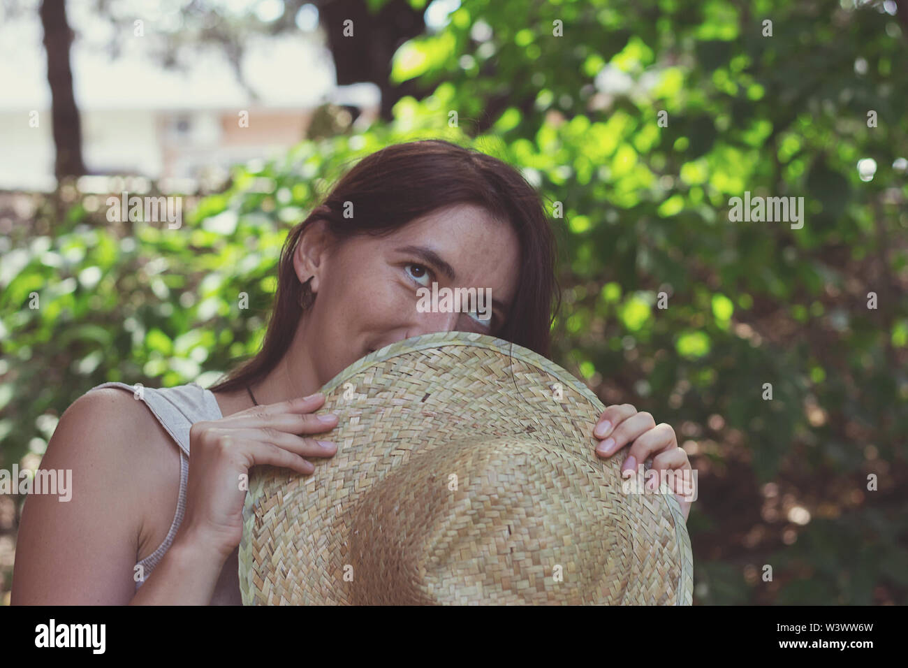 The woman covered part of her face with a straw hat Stock Photo - Alamy
