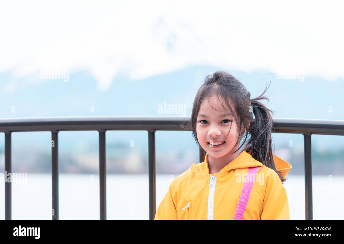 Kid is standing in front of Kawaguchiko lake and mount fuji in winter. Stock Photo