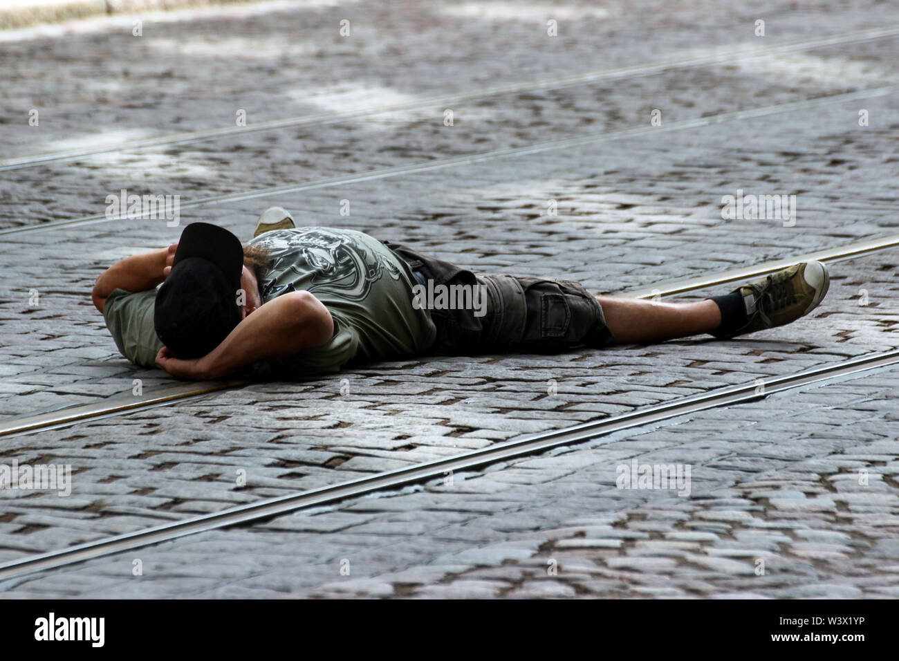 Young man laying on tramway tracks at Kallio Block Party 2016 in Helsinki, Finland Stock Photo