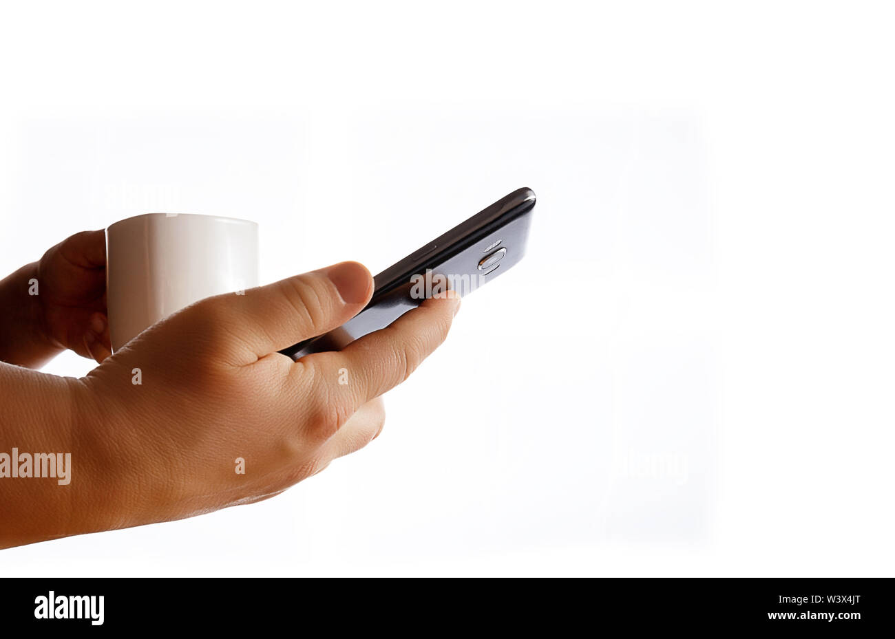 Hands holding mobile phone and coffee cup. Middle age woman using smartphone. White bacground. Stock Photo