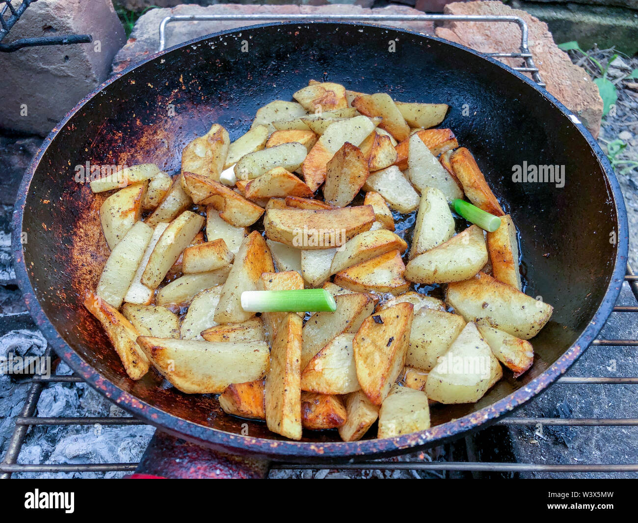 Cooking fried potatoes in outdoor conditions on fire Stock Photo Alamy