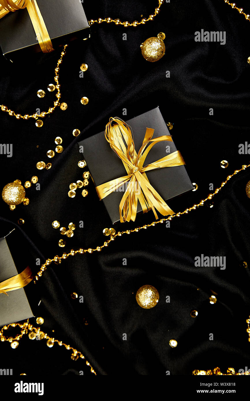 View of Luxury black gift boxes with gold ribbon on shine background. Christmas ...