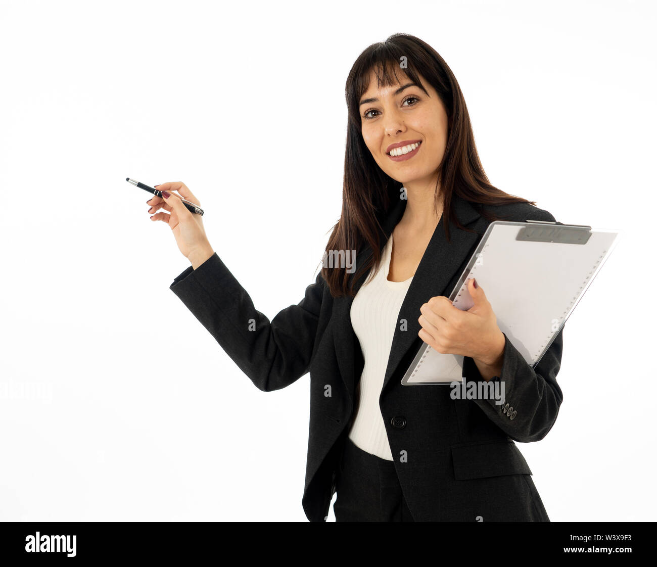 Close up of young pretty business woman standing pointing and holding a folder. Smiling feeling confident and successful. In people business education Stock Photo