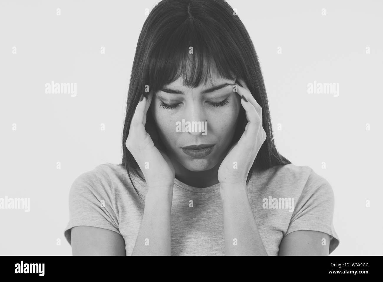 Close up of a young sad woman, serious and concerned, looking worried and thoughtful. Feeling sorrow and depression. Isolated in black and white. In f Stock Photo