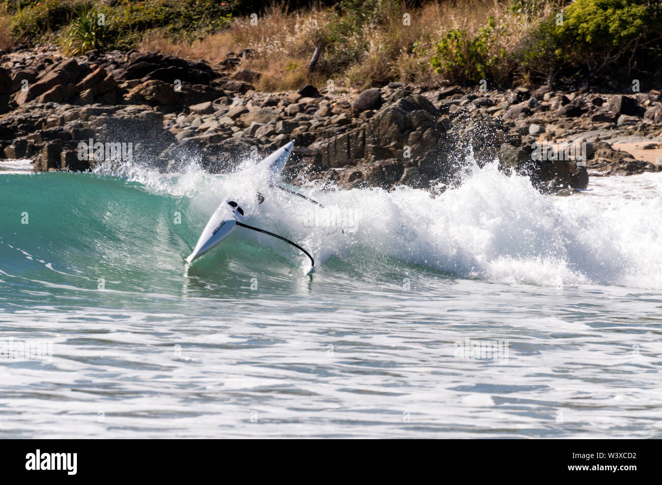 A young Australian woman riding the surf and capsized from her kayak in
