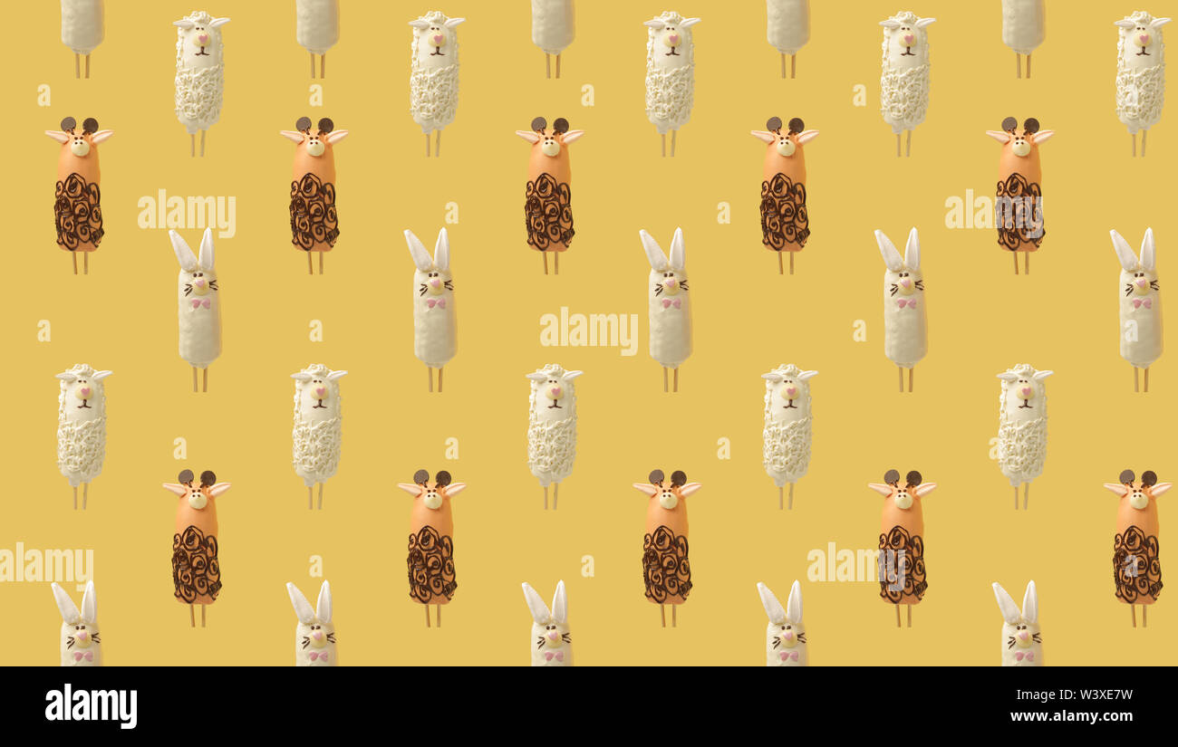 Colorful pattern consisting of bananas in chocolate in the form of various animals on yellow background. From top view Stock Photo