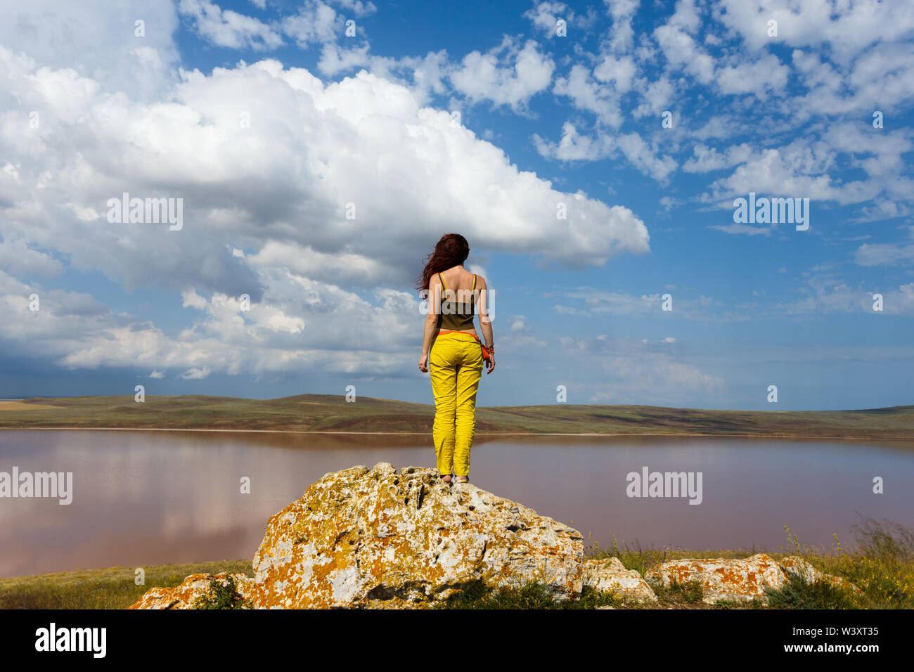 Attractive woman stands in front of the lake. Relax and travel. Stock Photo