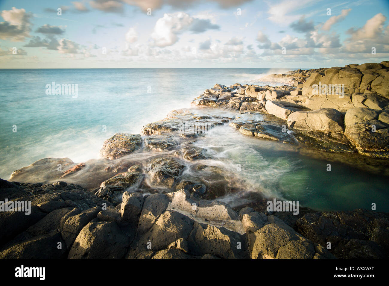 Queen's Bath is a tide pool among volcanic rock at the beach in ...