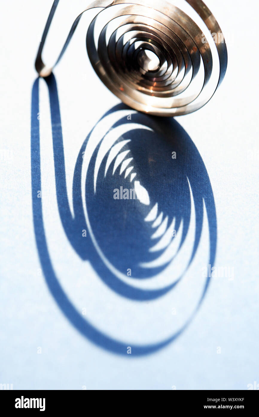 Industrial concept. Closeup of shadow of spiral on blue background Stock Photo