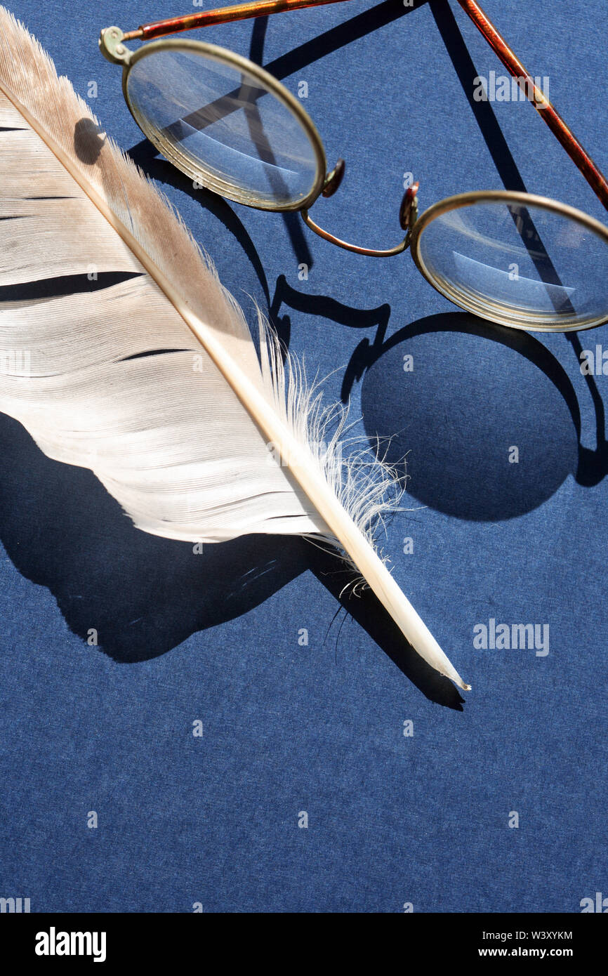 Old spectacles with shadow near feather against sun light Stock Photo ...