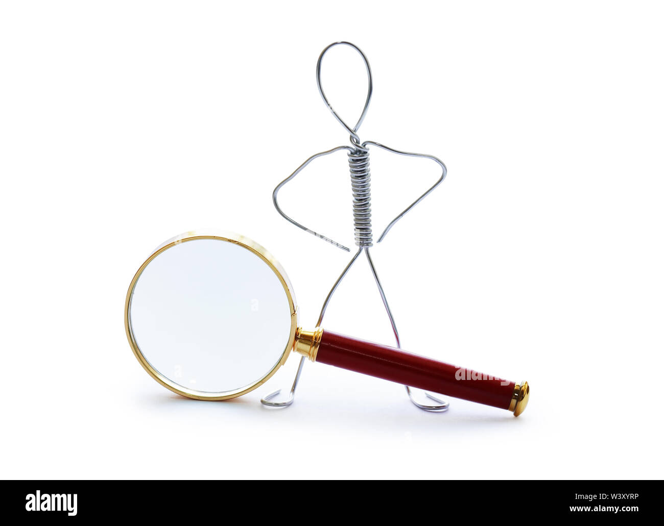 Man made from aluminum wire near magnifying glass Stock Photo