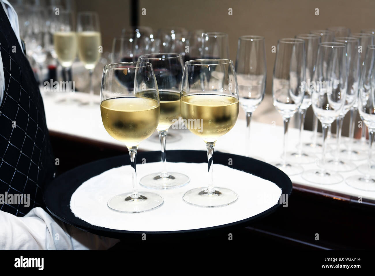 Cocktail party. Waiter holding platter with cold white wine Stock Photo