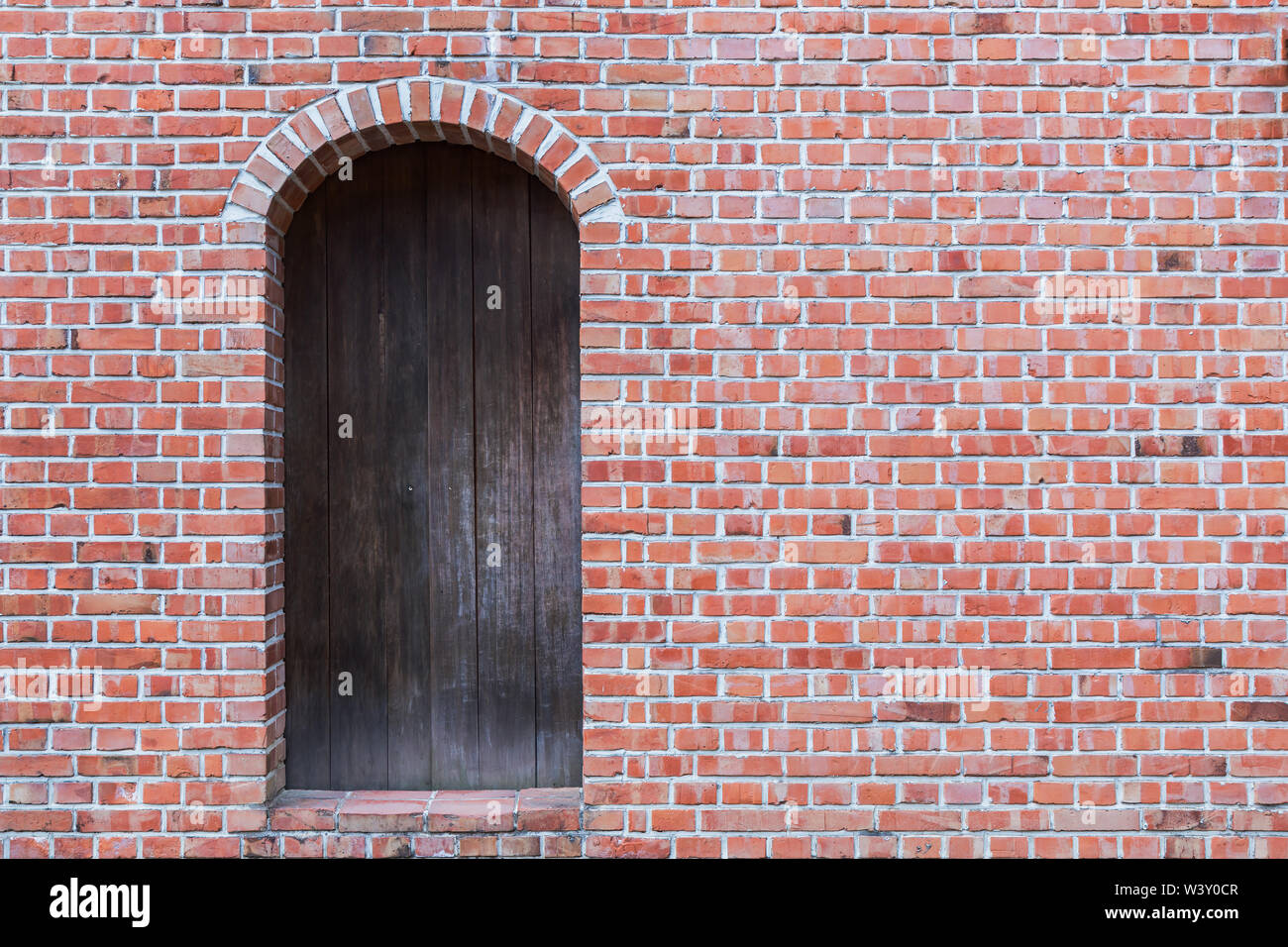 Old red brick wall with wooden door Stock Photo - Alamy