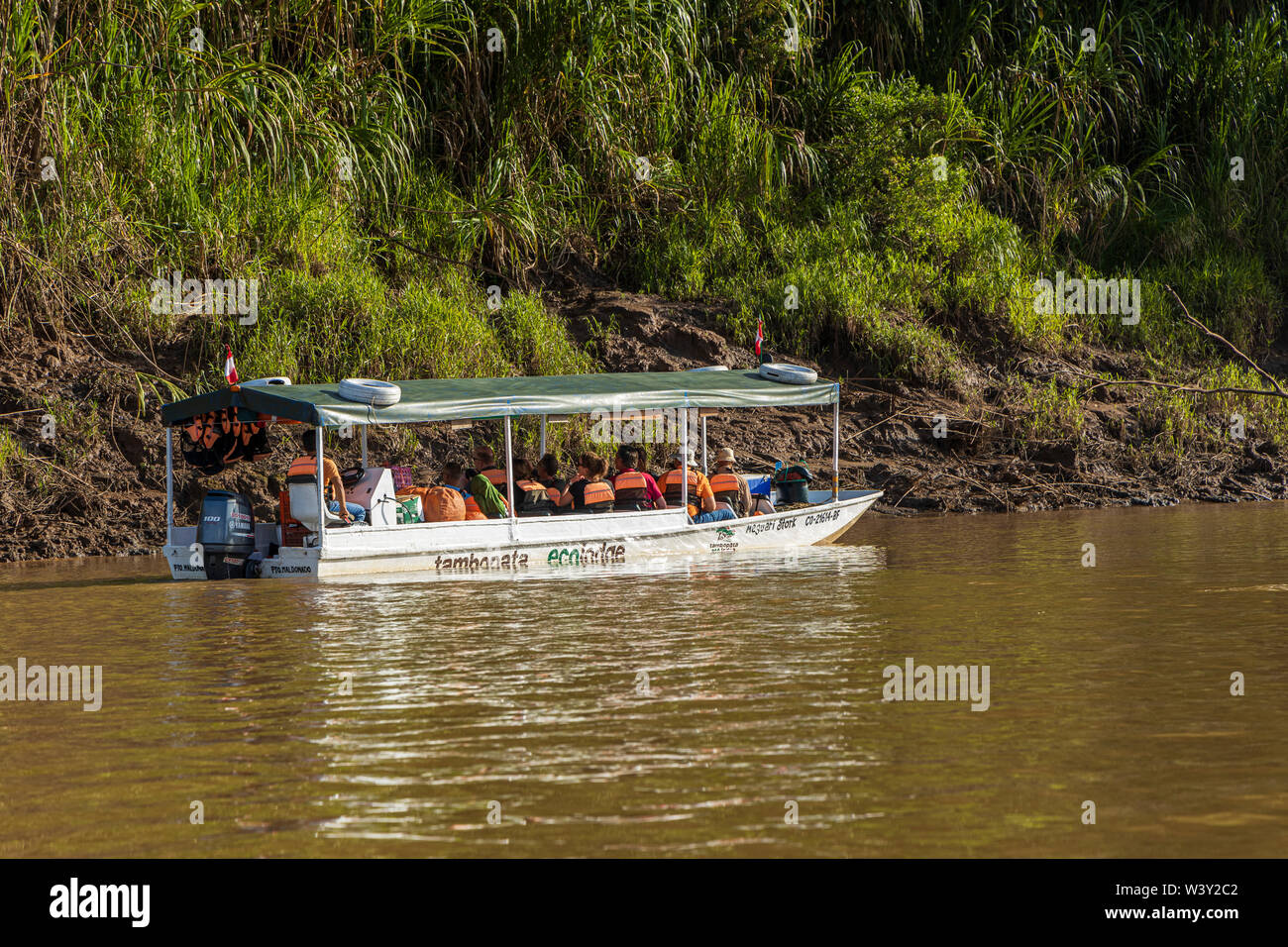 Tourists travelling by boat on the River Tambopata in the Amazonia region of Peru, South America Stock Photo