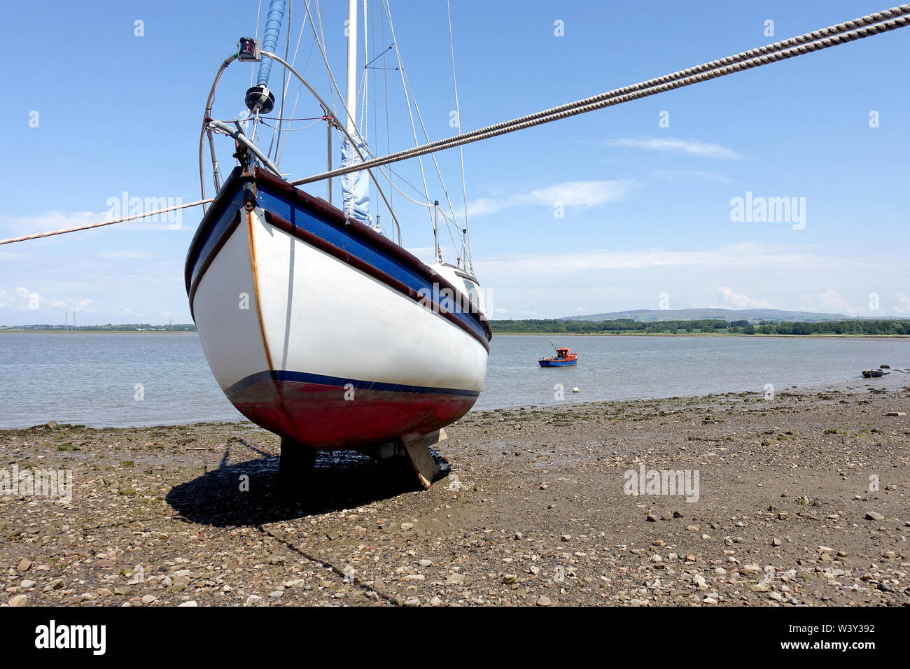 Cruising yacht beached on the foreshore of the River Lune estuary at Glasson Dock, Lancashire, and waiting for the tide. Stock Photo