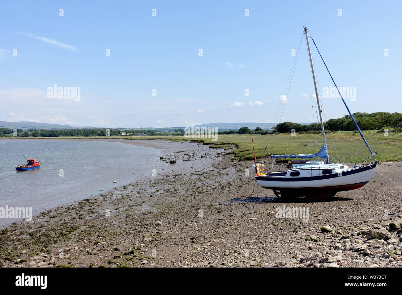 Cruising yacht beached on the foreshore of the River Lune estuary at Glasson Dock, Lancashire, and waiting for the tide. Stock Photo