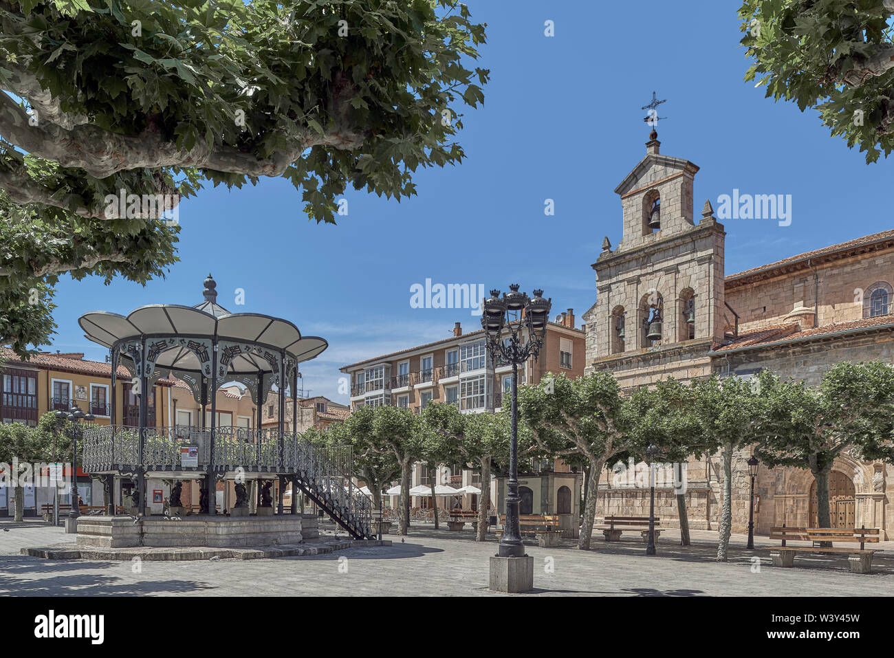 Plaza Mayor porticoed with stone houses around a music temple. On the right the Church of San Martín, building XVI century. Briviesca Burgos, Spain Stock Photo