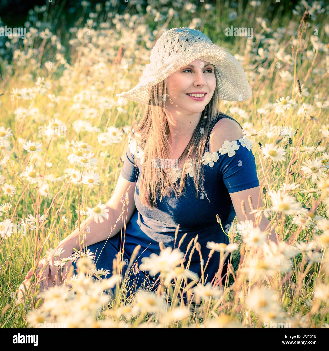 Lifestyle environmental portrait. Latvian model in field of flowers. Stock Photo