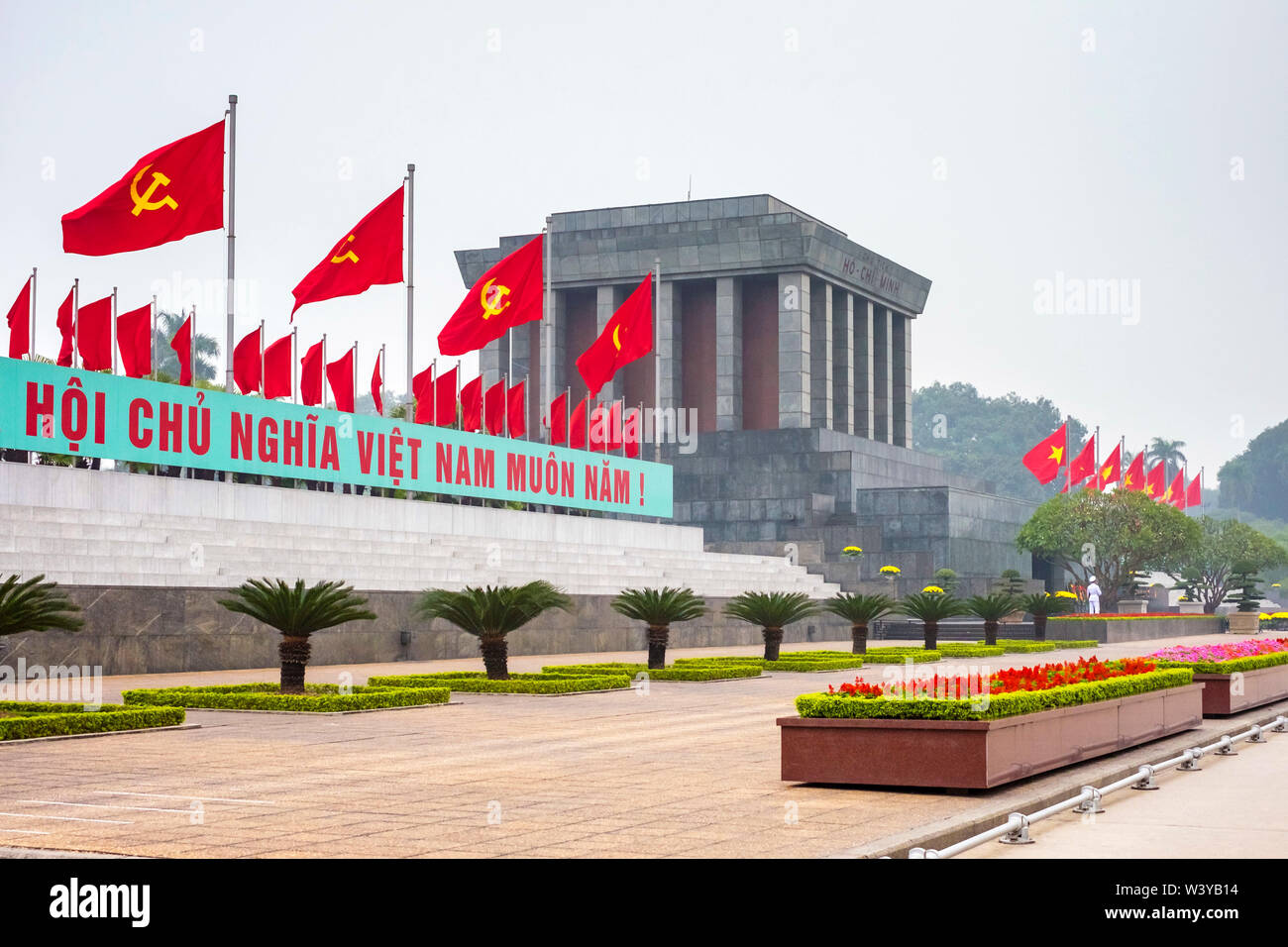 Communist flags fly outside of Ho Chi Minh Mausoleum on Ba Dinh Square, Hanoi, Vietnam Stock Photo