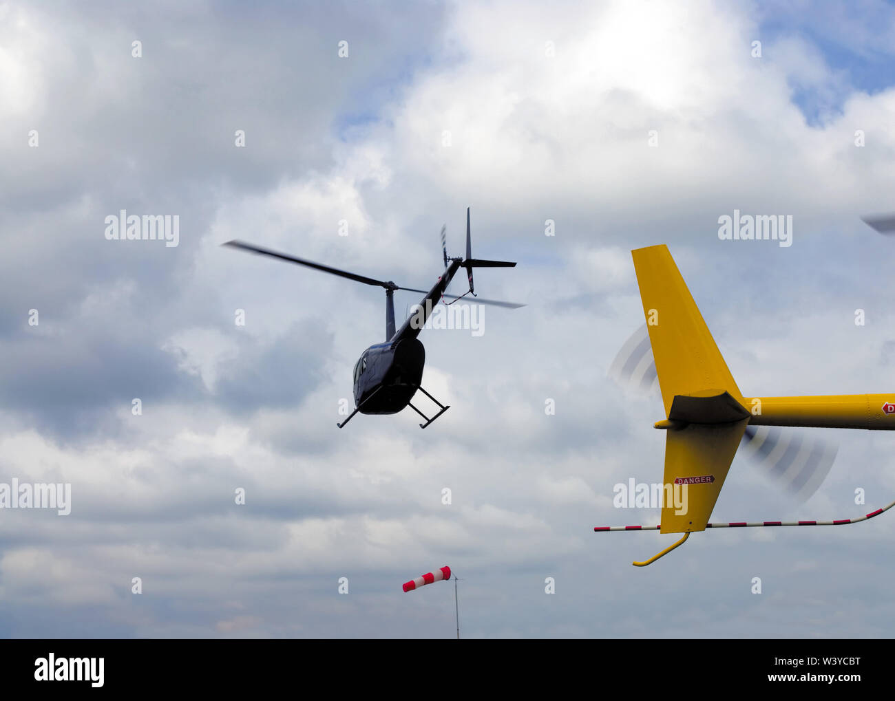 Small helicopter against cloudy sky Stock Photo
