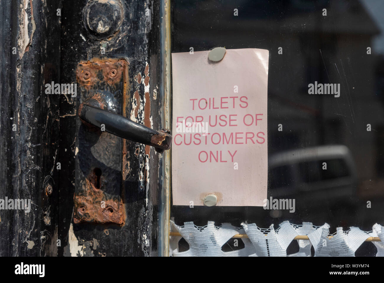 Seaton, Devon, England, UK. July 2019.  Notice on an old cafe door. Toilets for customer use only. Stock Photo