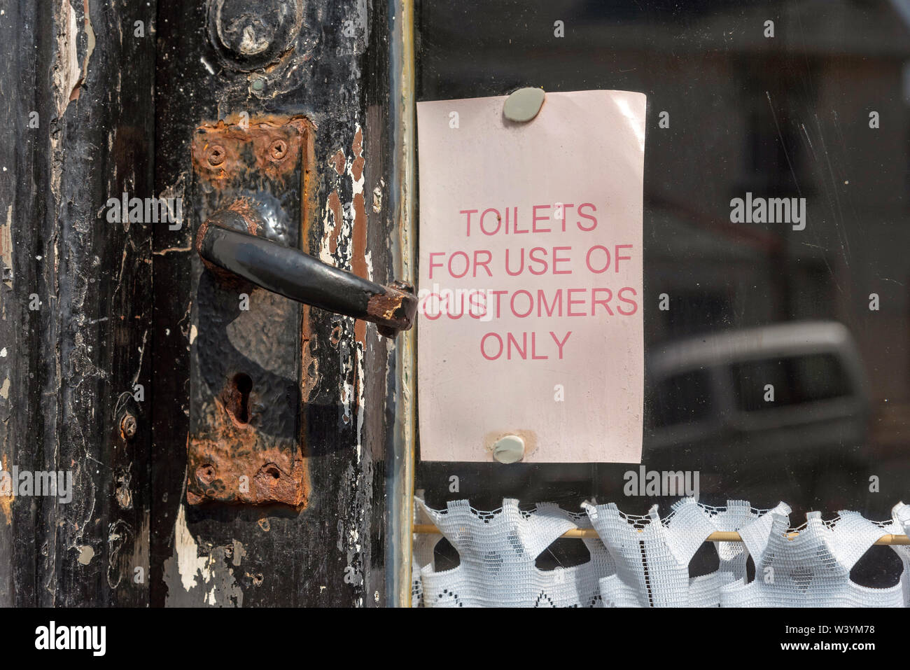 Seaton, Devon, England, UK. July 2019.  Notice on an old cafe door. Toilets for customer use only. Stock Photo