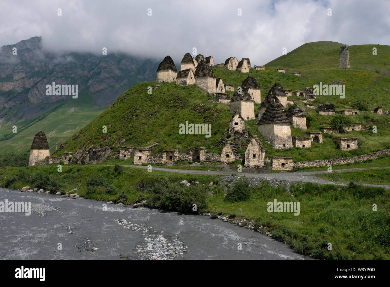 View of tombs and crypts of the Alanian necropolis dating back to the 12th century outside the village of Dargavs known locally as the “city of the dead,“ which sits on the slope of a hill overlooking the Fiagdon River in Prigorodny District of the Republic of North Ossetia-Alania in the North Caucasian Federal District of Russia. Stock Photo