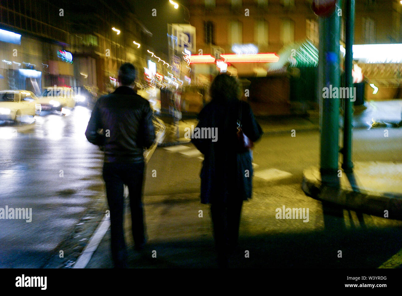 Rear view of a couple walking in a street at night, Toulouse, Haure-Garonne, Languedoc-Roussillon-Midi-Pyrénées, France Stock Photo