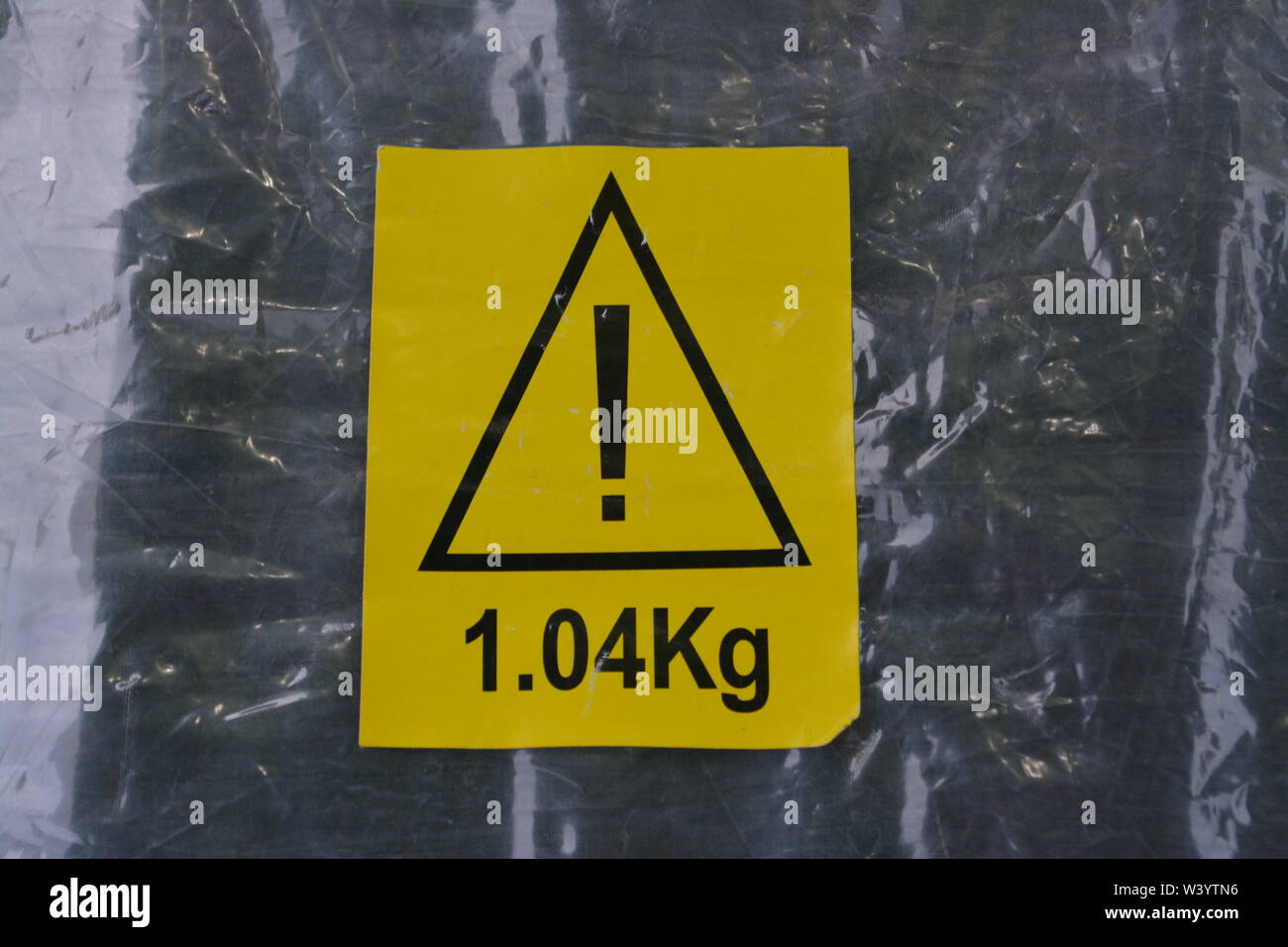 Yellow warning sticker showing weight of item on empty transparent plastic bag re nanny state health and safety risk assessment Stock Photo