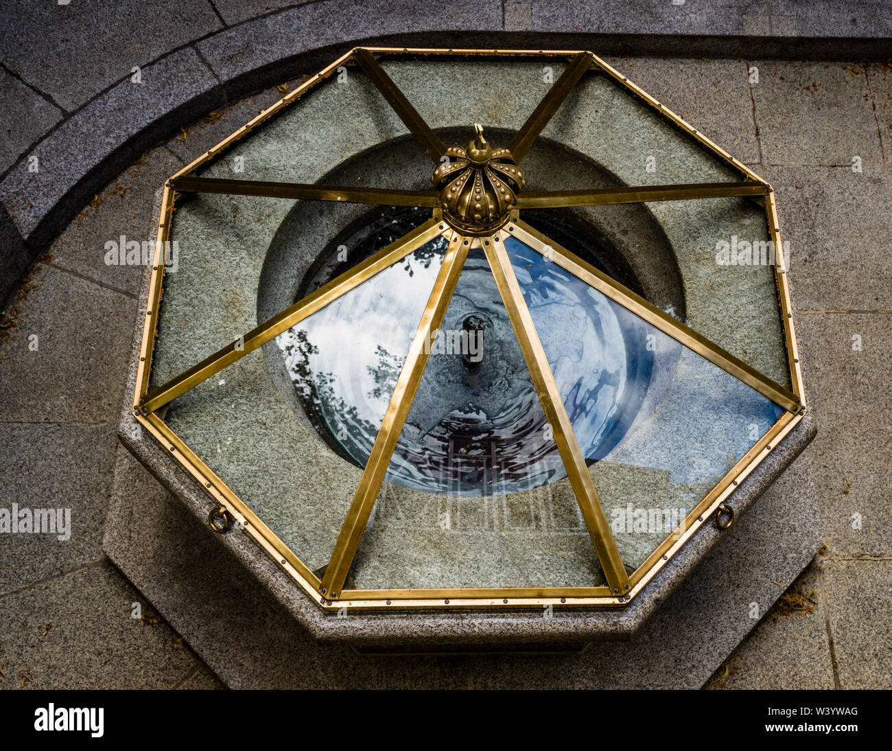 A glass-and-brass cover seals the shaft of the Max-Brunnen spring in Bad Kissingen, Germany, one of the seven healing springs of the spa town, which has counted among the UNESCO World Heritage "Great Spas of Europe" since summer 2021. Men used to climb down ladders into the depths to draw the water by hand. Stock Photo