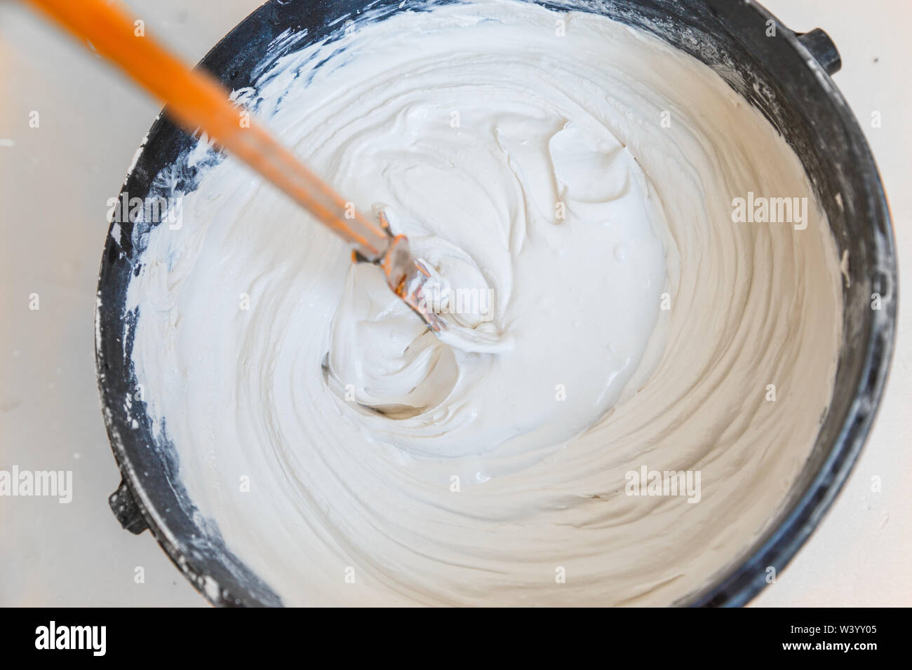 mix plaster with putter mixer in the bucket Stock Photo