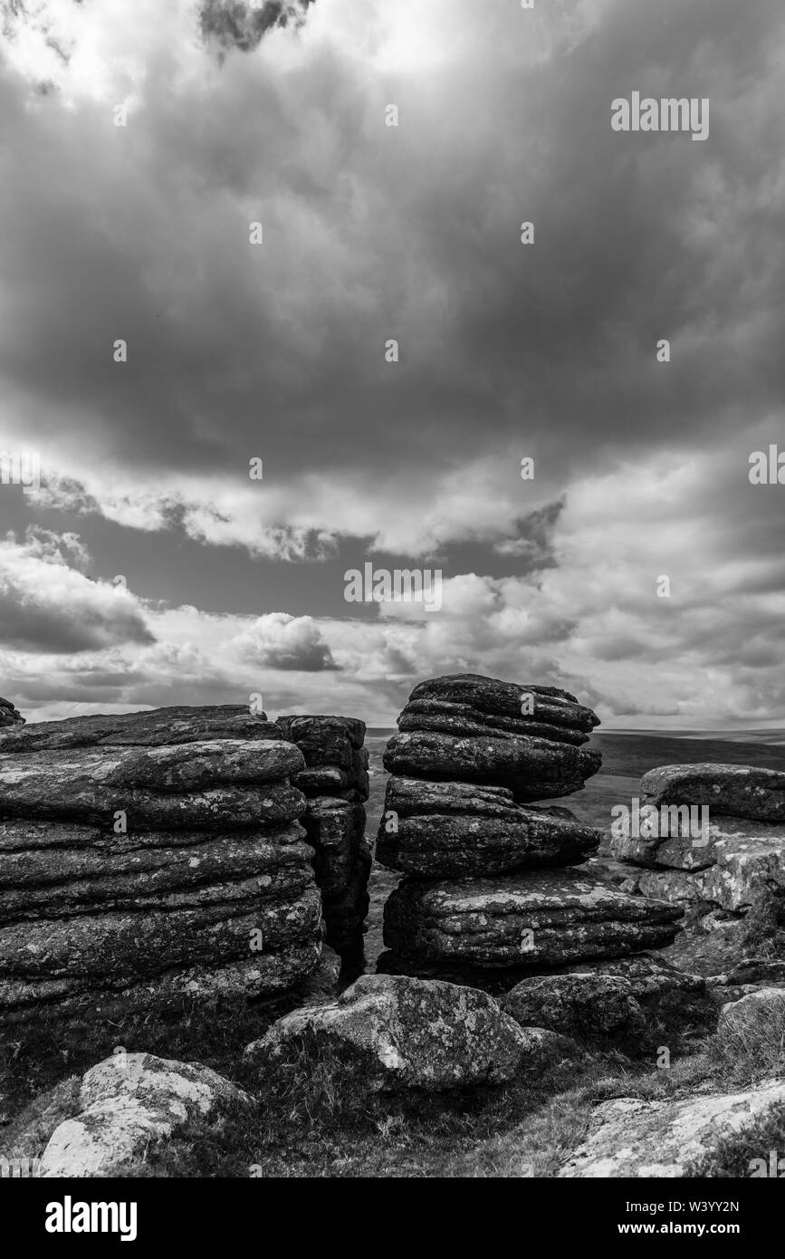 Granite tor on Dartmoor national park, moody, cloudy sky, landscape black and white Stock Photo