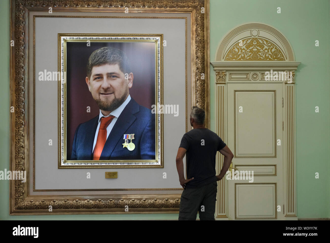 A visitor views a framed photograph bearing the image of Ramzan Kadyrov the Head of the Chechen Republic displayed at Akhmat Kadyrov museum overwhelmingly a shrine to Akhmat and Ramzan Kadyrov in Grozny the capital city of Chechnya in the North Caucasian Federal District of Russia. Stock Photo